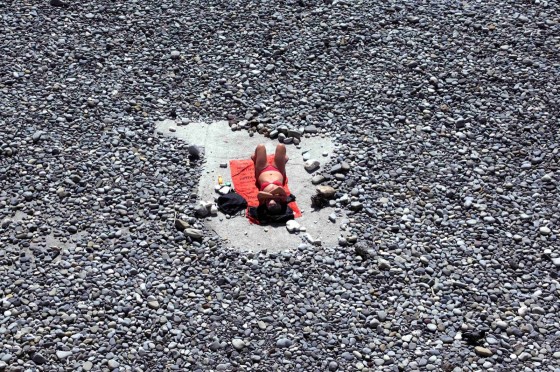 A woman takes advantage of warm spring weather temperatures on the beach in Nice