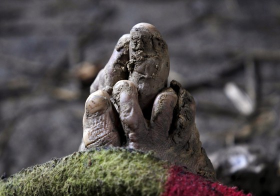 The mud-covered feet of a victim, who died after a hillside collapsed onto a house, is pictured at Ledhan village