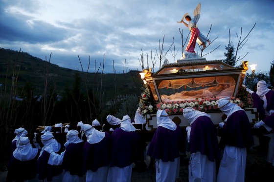 Penitents carry a casket containing a statue of Jesus during a Holy Week procession in Villarosa