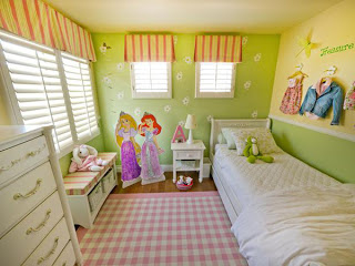 The pink accents add a soft femininity to the room, and they are all tied together by the pink checkered area rug. Also, the butterflies that are so delicately placed around the room bring in a feeling of the outdoors. A great hand me down bed that was originally oak colored fills the room.